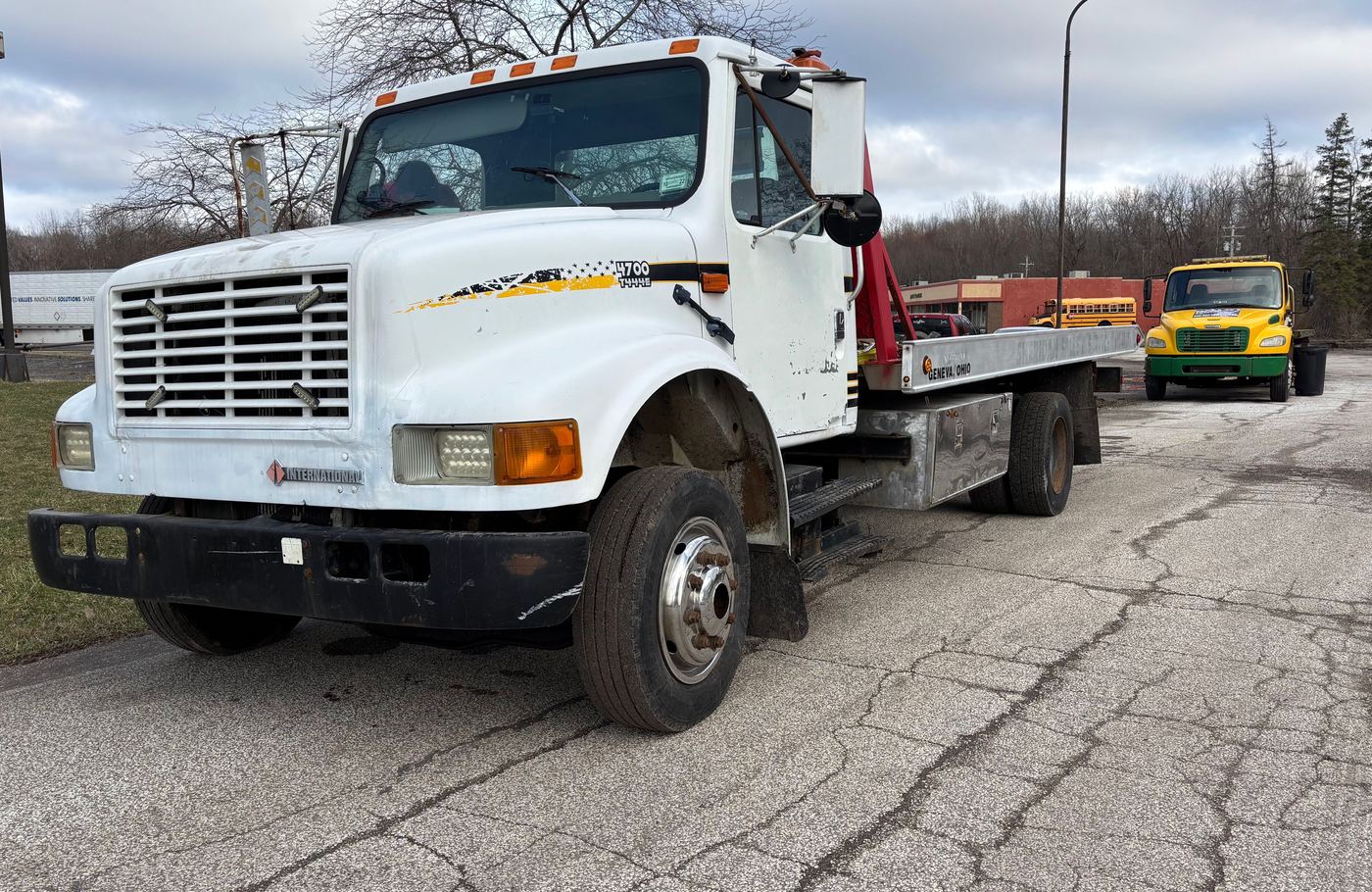The Anytime Roadside Services flatbed tow truck parked in a lot between calls